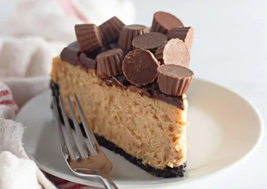 Slice of peanut butter cheesecake on a plate with a fork.