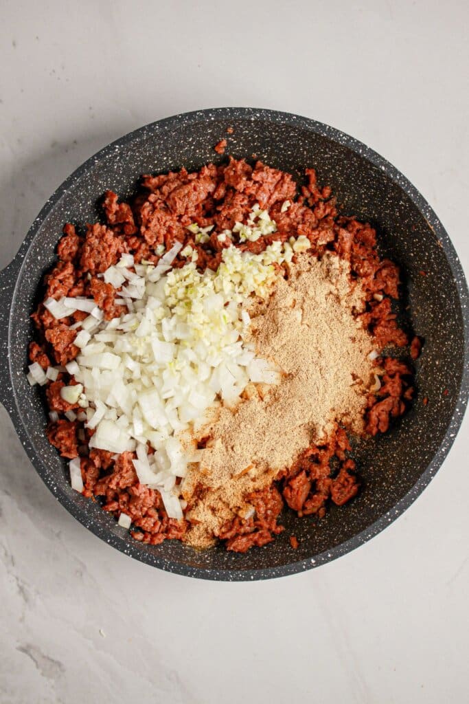 Beef, onions, and garlic in a skillet.