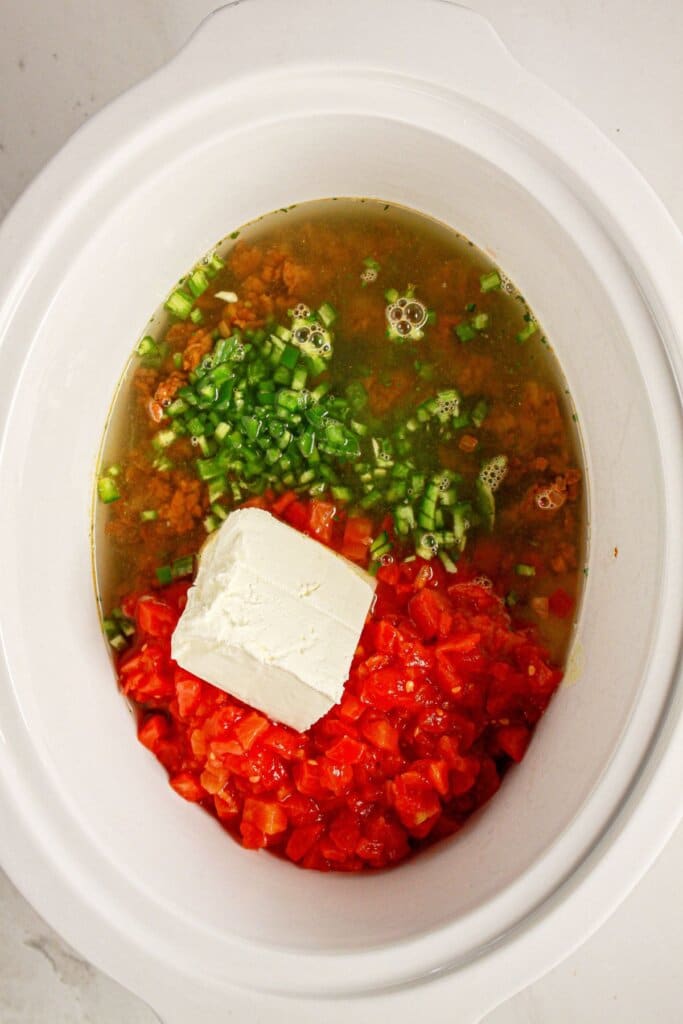 Cream cheese, tomatoes, broth, and jalapeno in a crockpot.