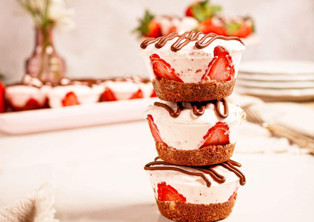 Three strawberry cheesecake cups stacked on top of each other.