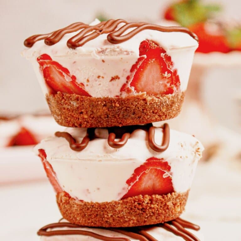 Two strawberry cheesecake cups stacked on top of each other.