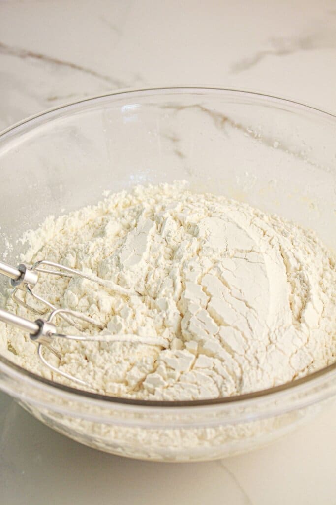 Dry ingredients being mixed into a glass bowl.