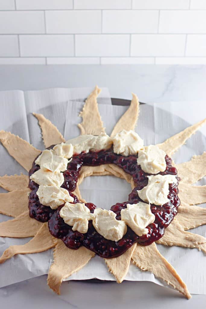 Cream cheese being added on top of dough.
