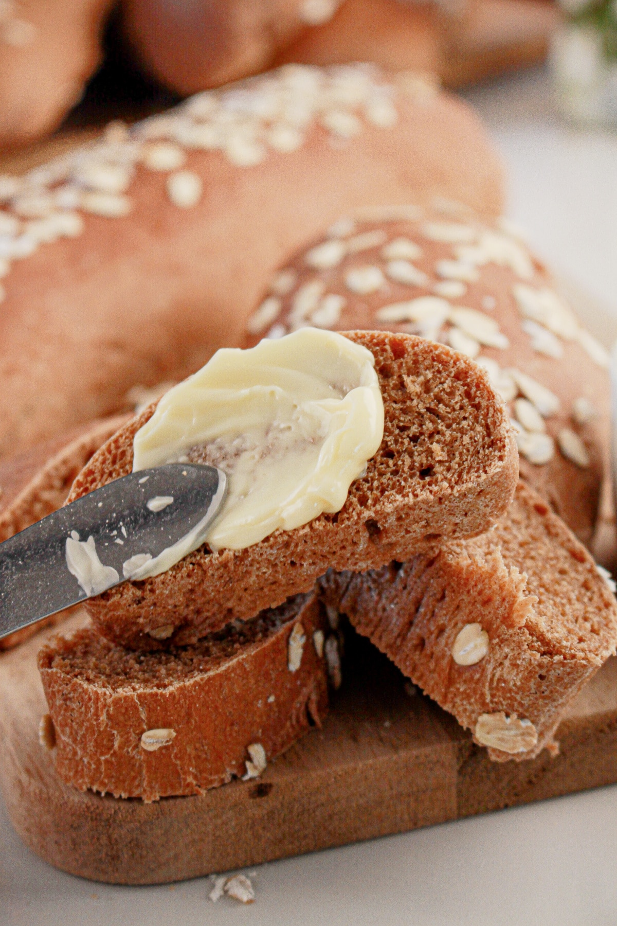 Butter being spread on a slice of bread.