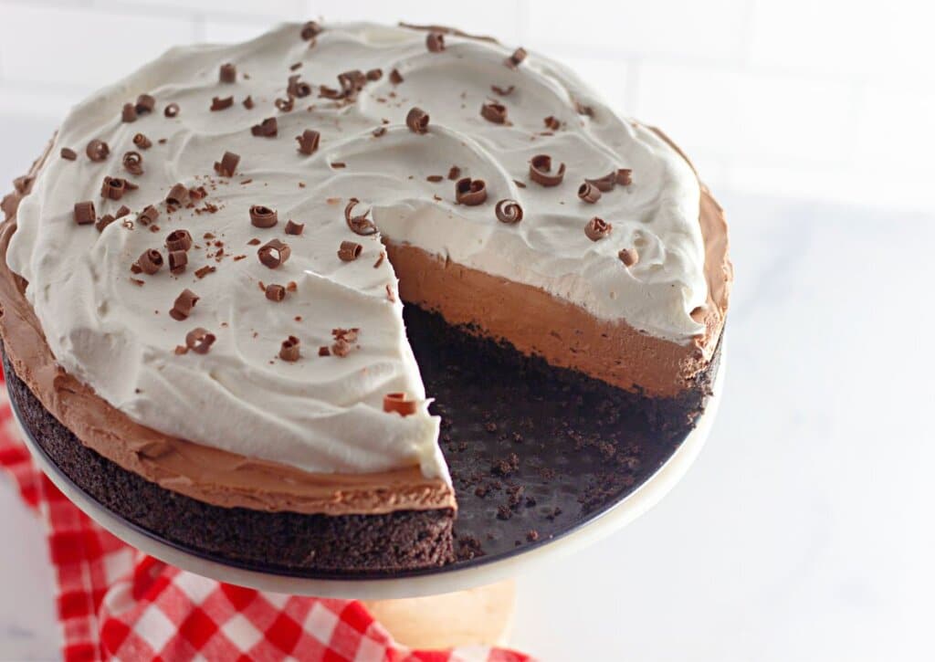No bake chocolate cheesecake on a cake stand.