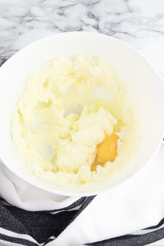 Butter, sugar, and eggs in a mixing bowl.