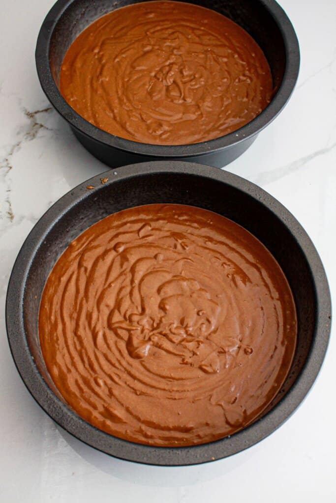 Cake batter in round cake pans.