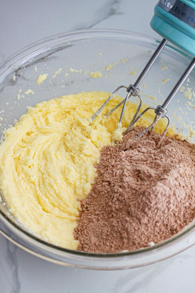 Dry ingredients being mixed into wet ingredients in a glass mixing bowl.