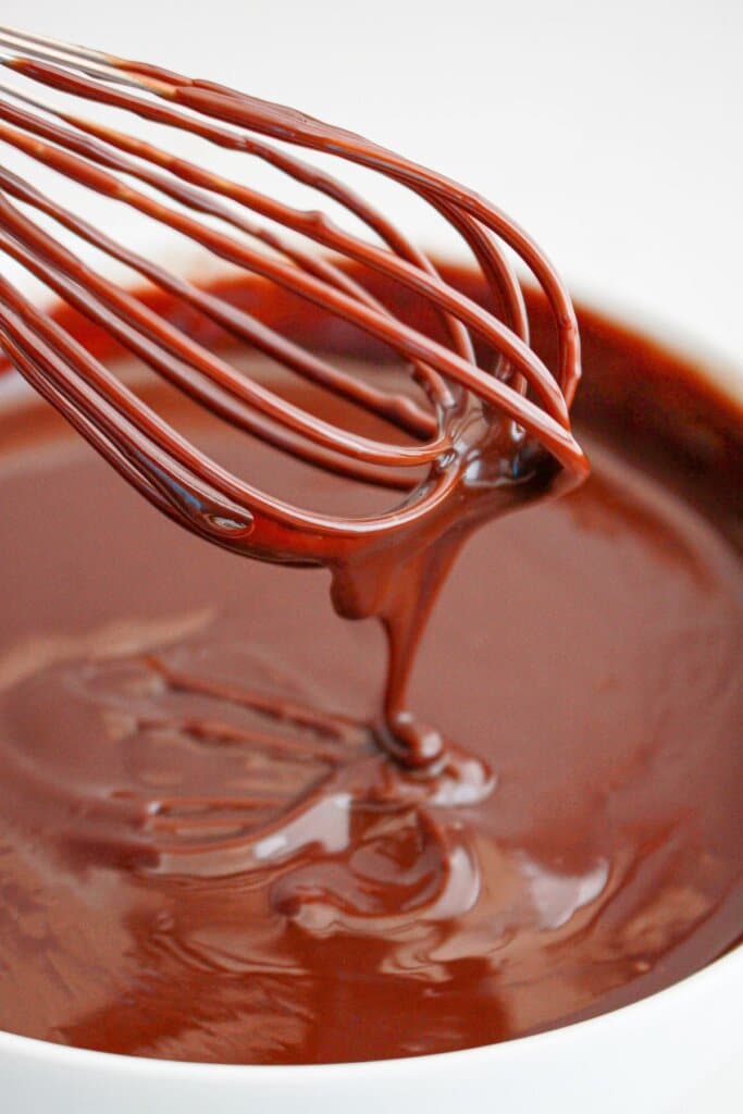 Chocolate ganache being mixed in a bowl.