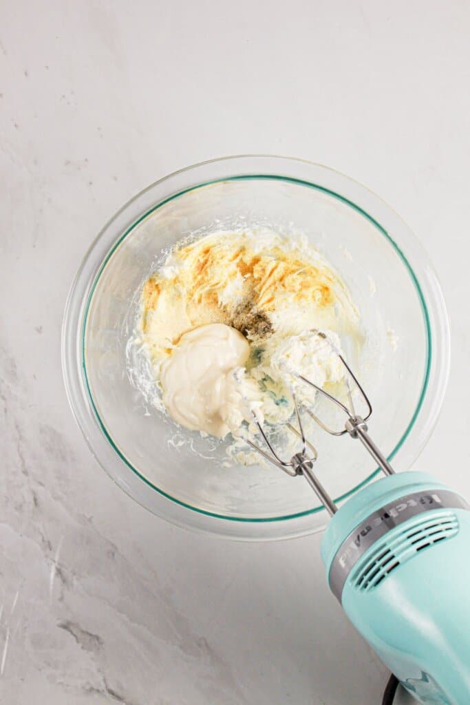Mayo, seasoning, and cream cheese in a glass bowl.