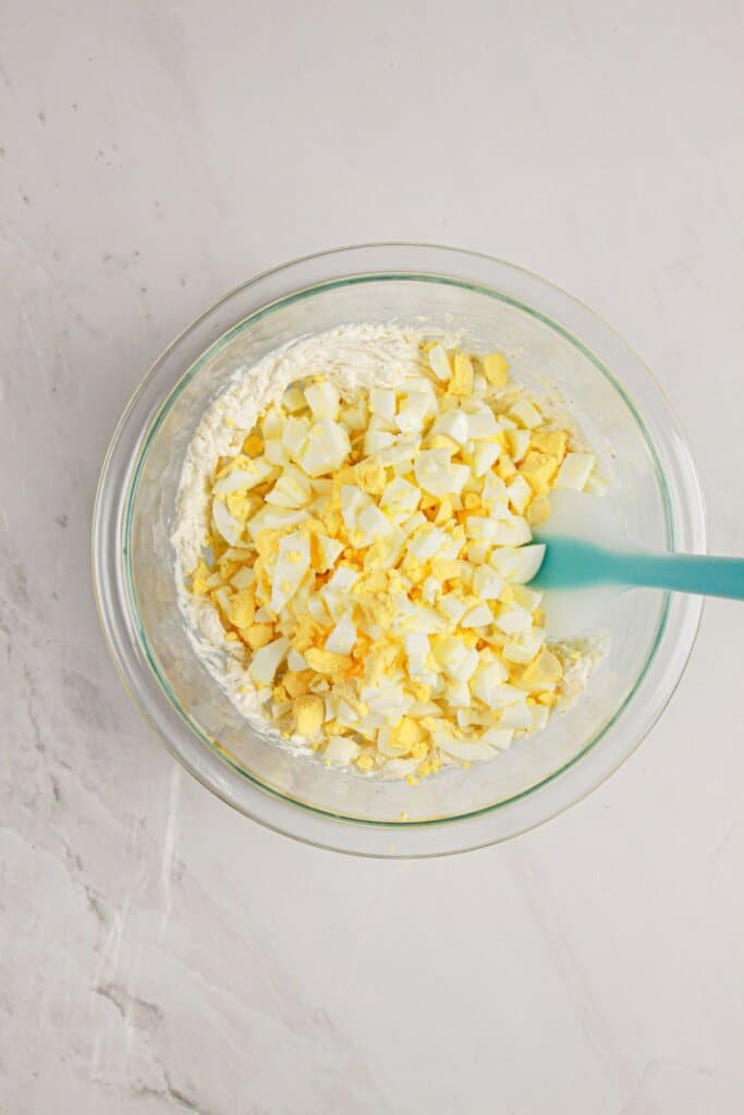 Ingredients being mixed in a glass bowl.