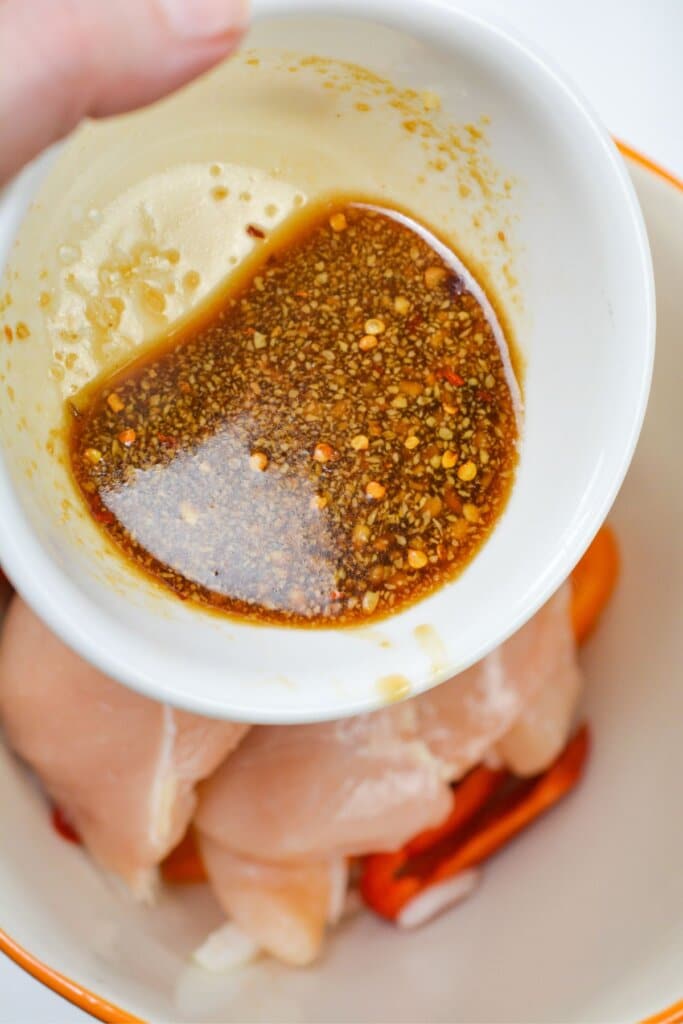 Marinade being poured into a large mixing bowl.