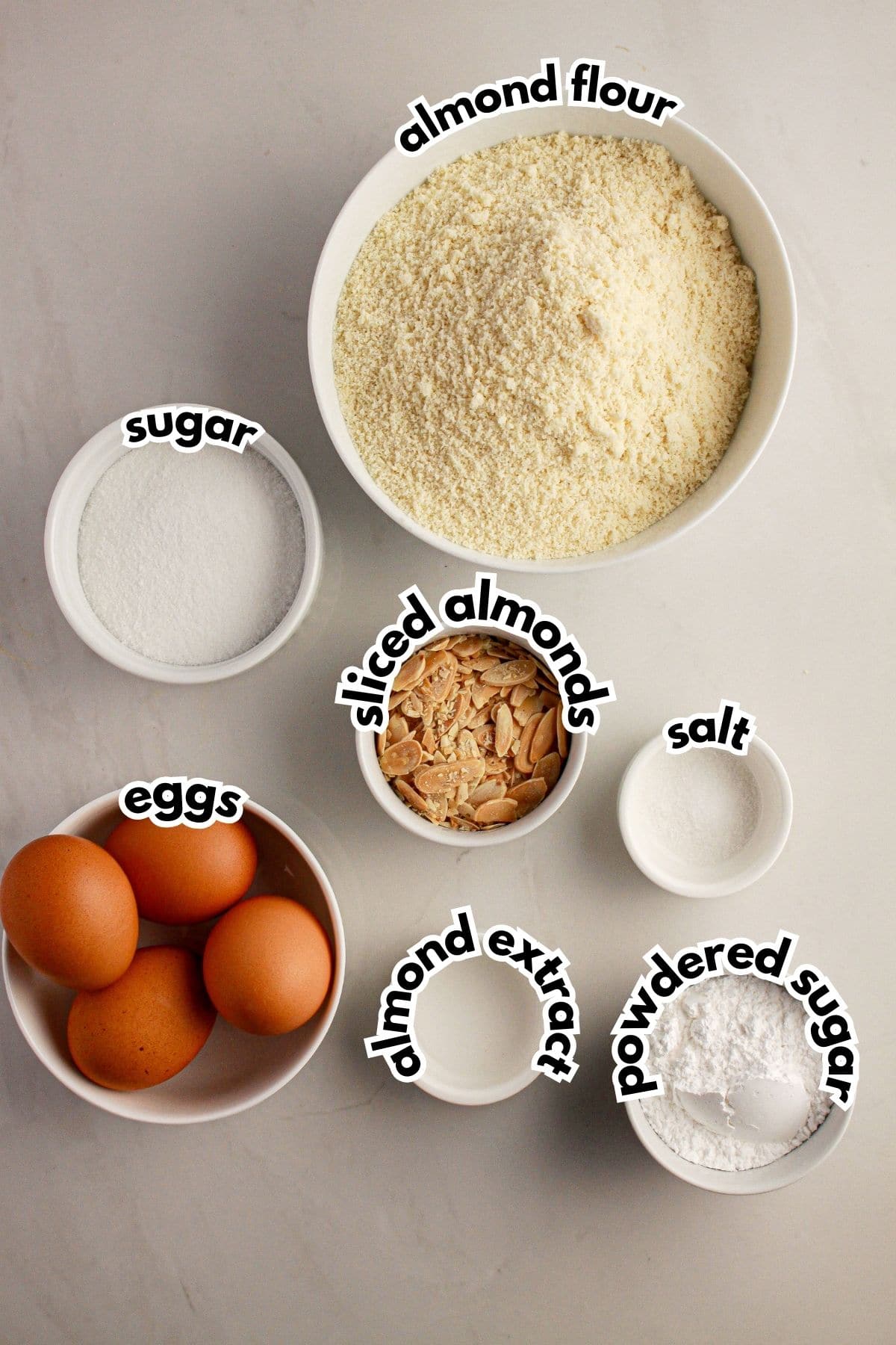 Bowls of ingredients labelled with text on a counter.