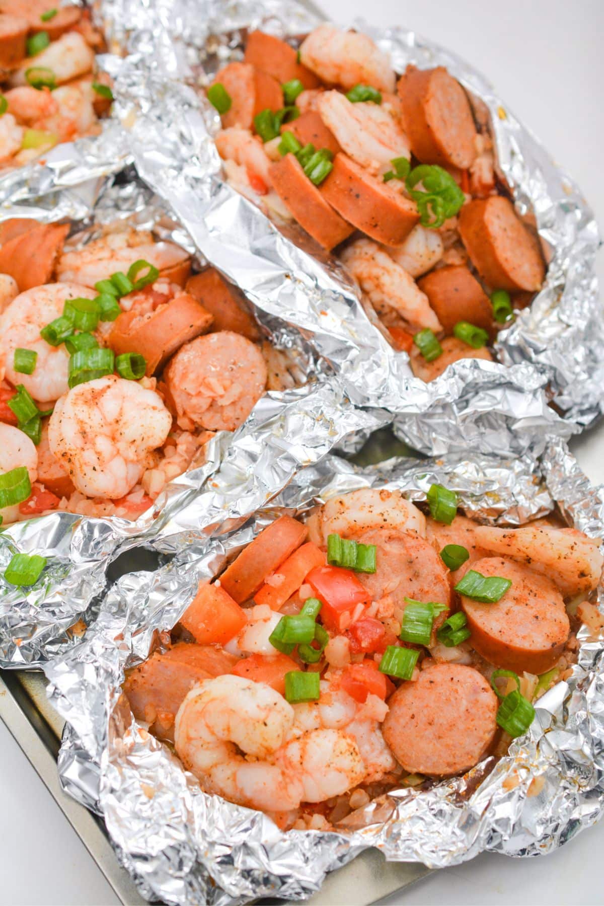 Foil packets on a baking sheet.