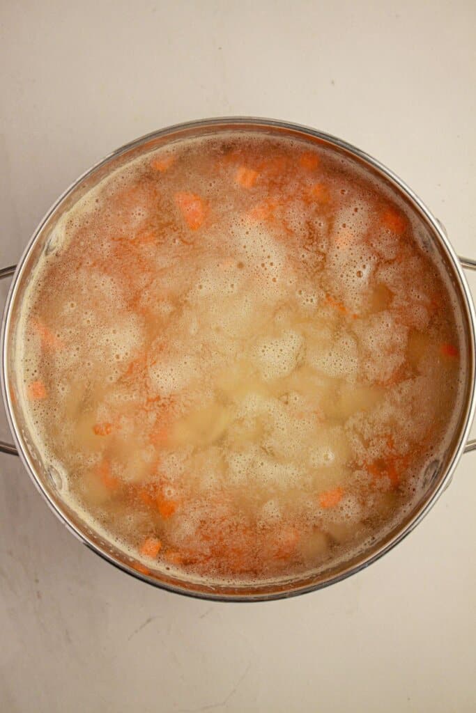 Potatoes and carrots in a large pot of water.