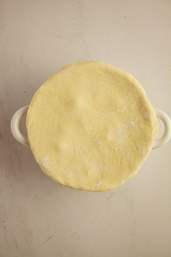 Crust being added on top of a baking dish.