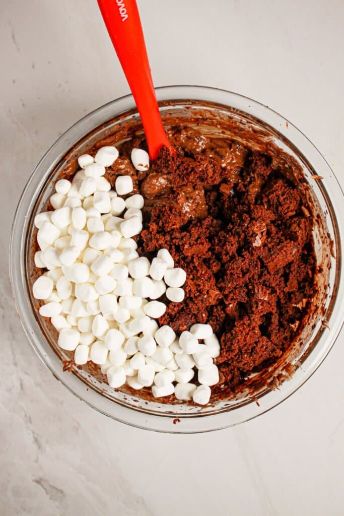 Marshmallows being stirred into chocolate pudding.