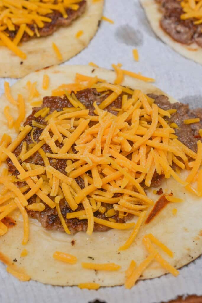 Cheddar cheese sprinkled on top of cheese and sausage.