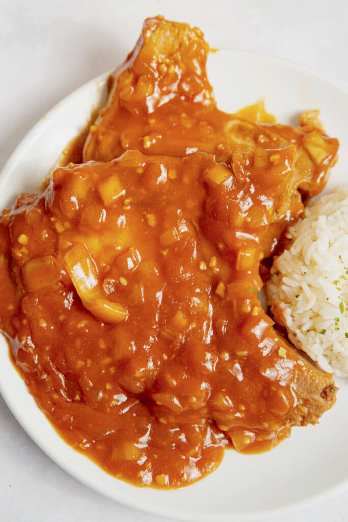 Pork chops and rice on a plate.