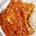 Pork chops and rice on a plate.