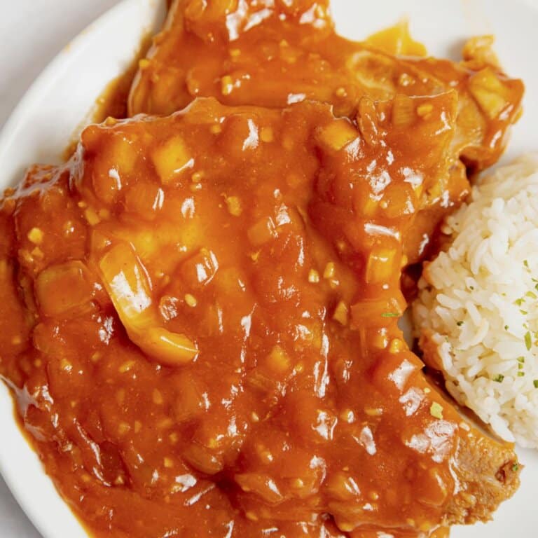 Pork chops and rice on a plate.