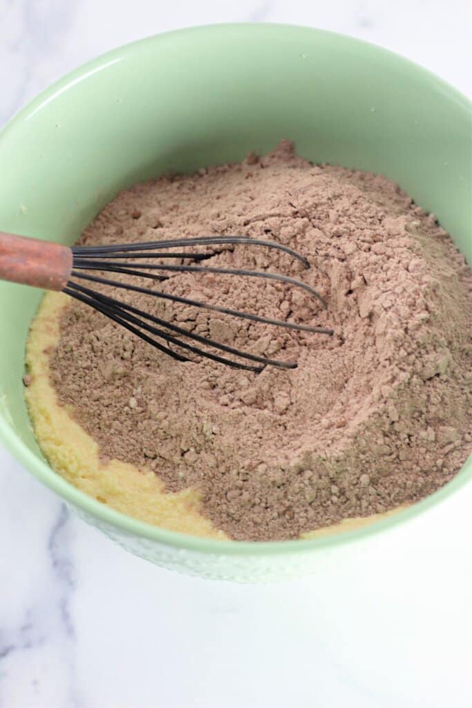 Batter being mixed in a green mixing bowl.
