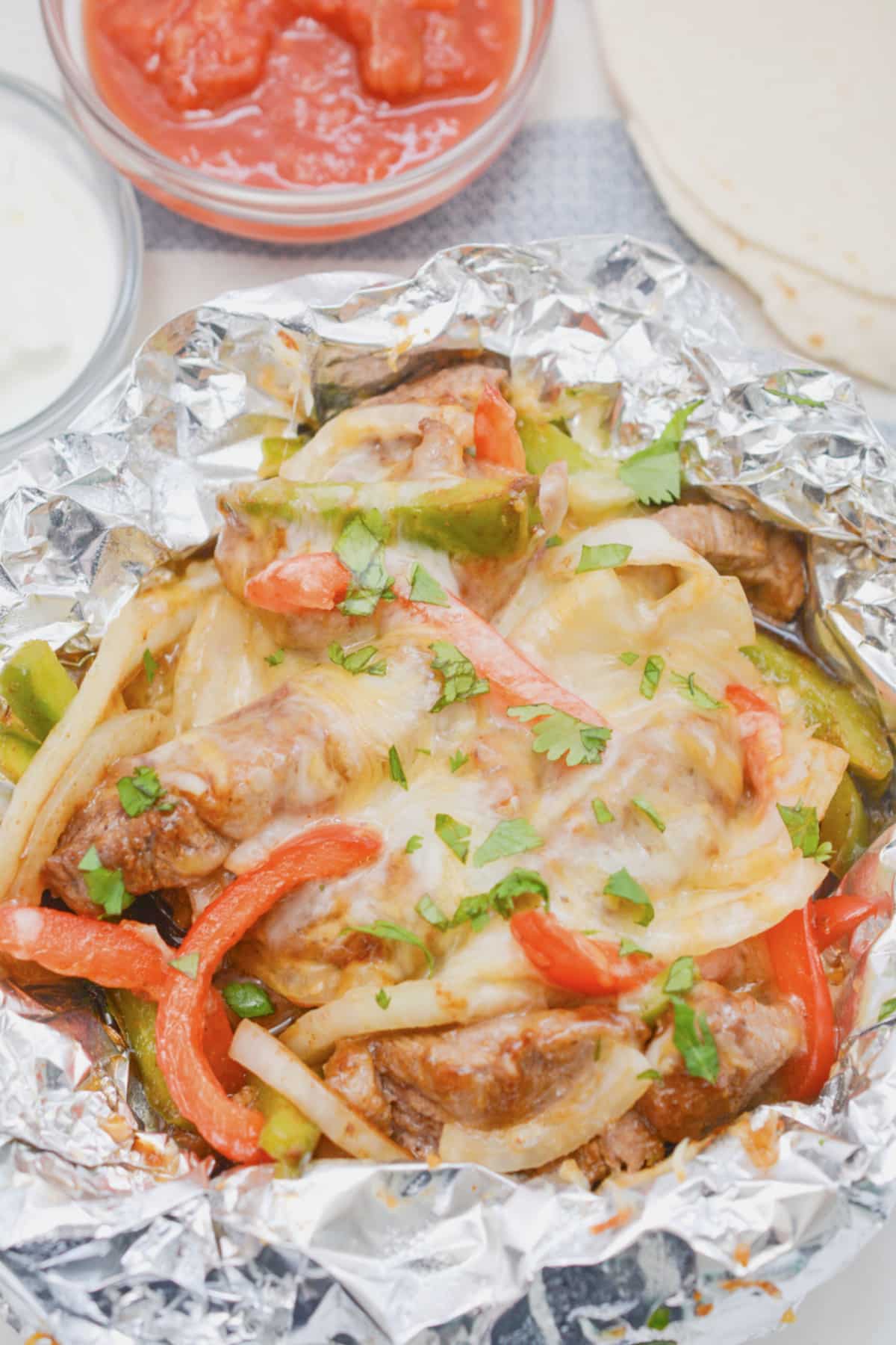 Steak fajitas foil packet on a plate.