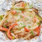 Steak fajitas foil packet on a plate.