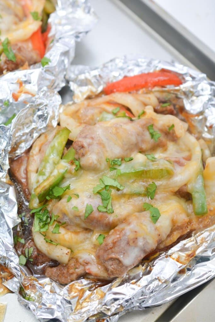 Steak fajitas foil packet on a plate.