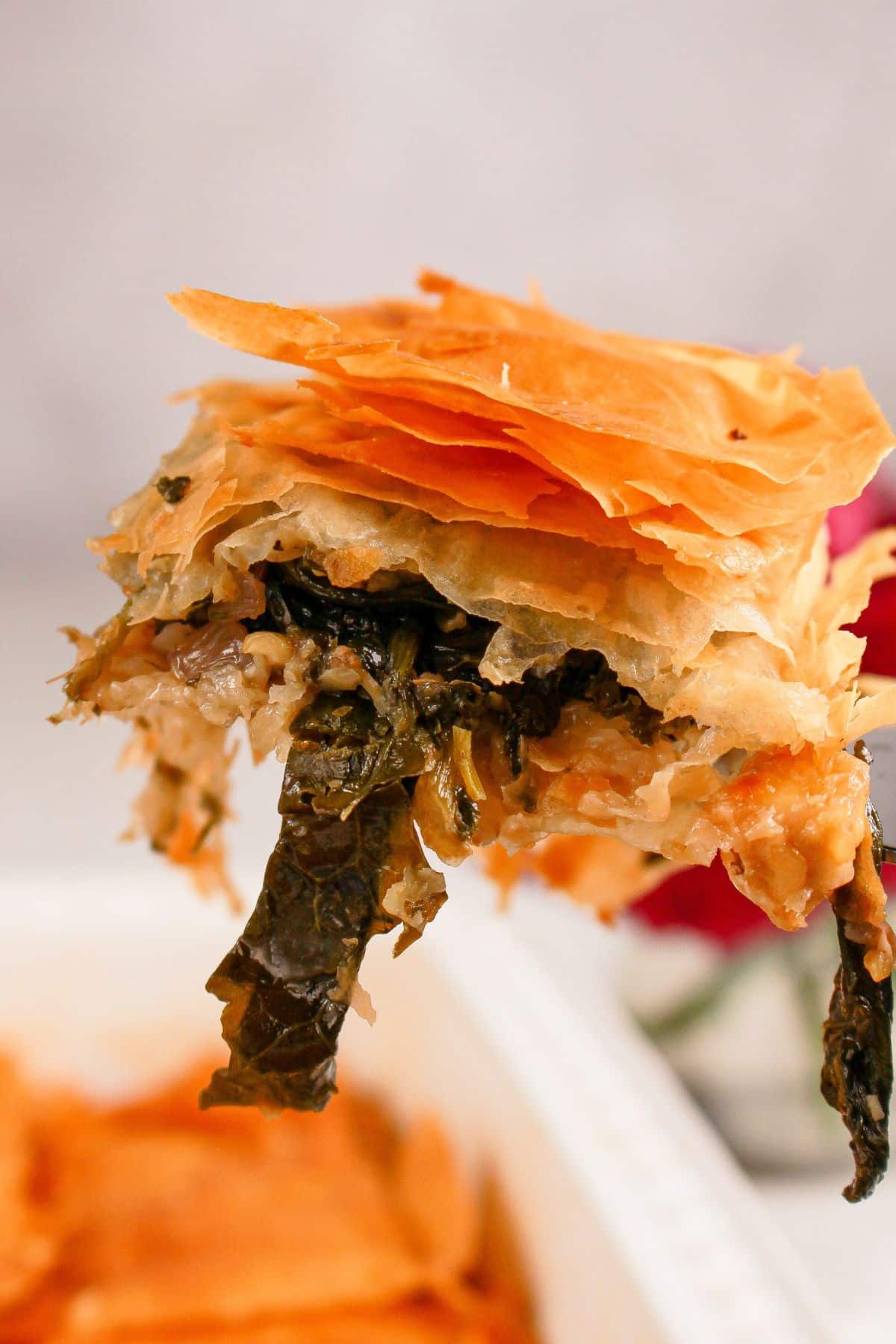 Slice of spanakopita on a spatula.