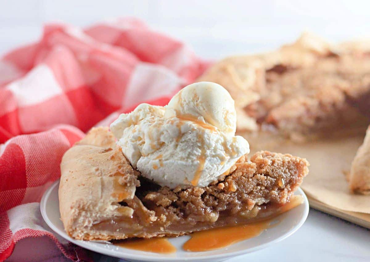 Slice of apple crumb galette on plate.