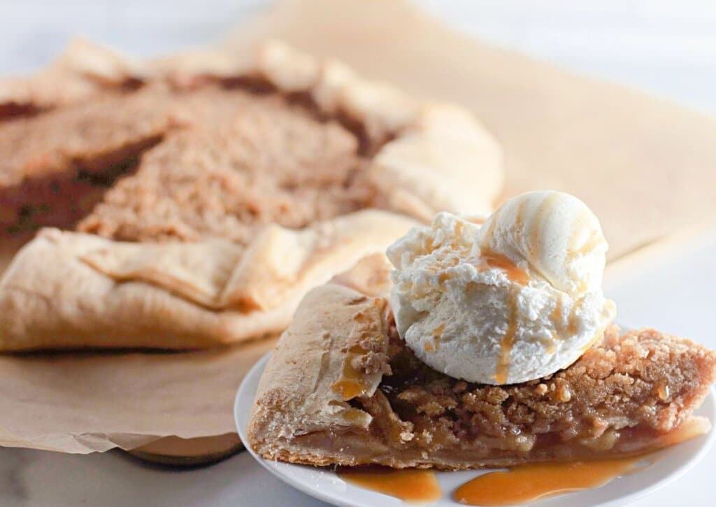 Slice of apple crumb galette on plate.