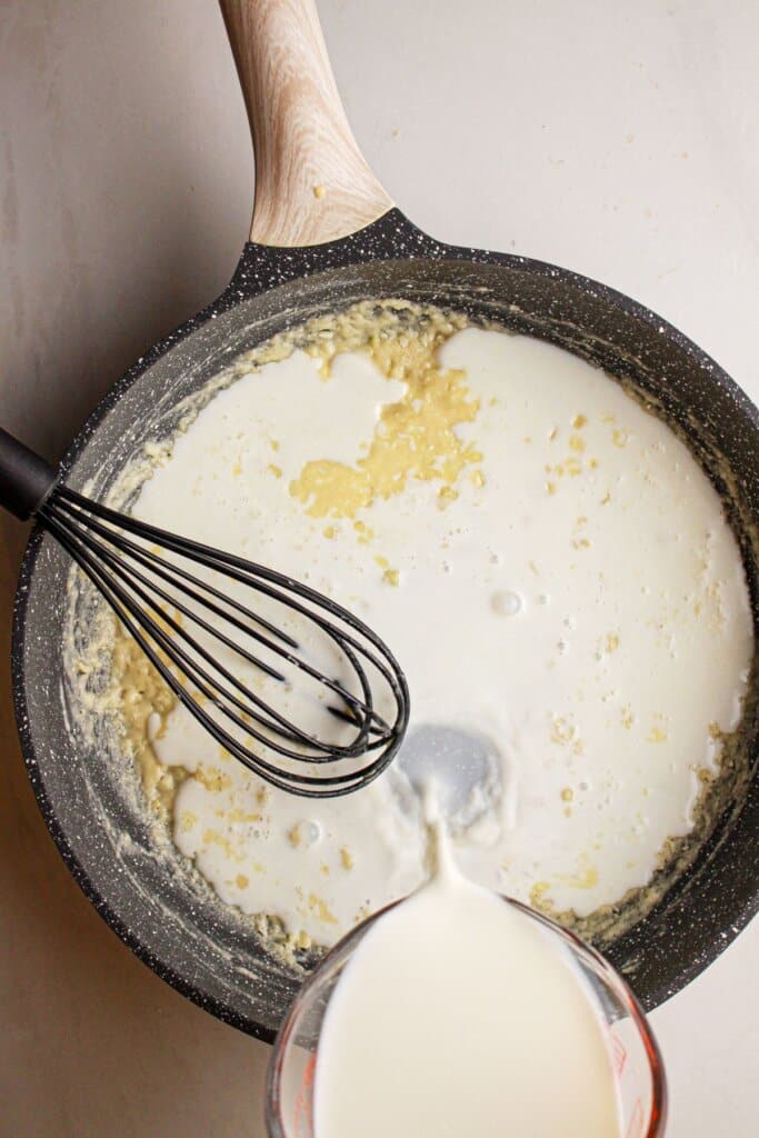 Roux being whisked in a skillet.