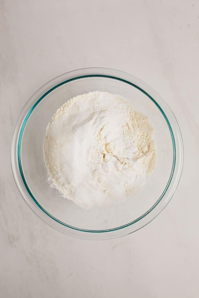 Dry ingredients being mixed in a glass bowl.