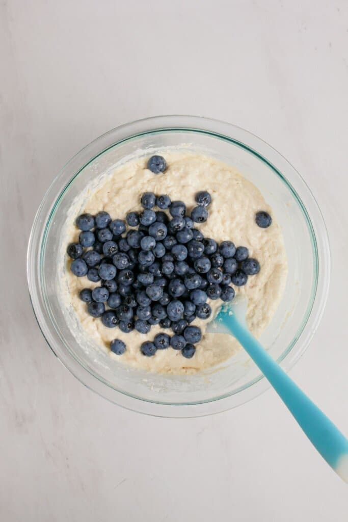 Blueberries are being folded into the batter.