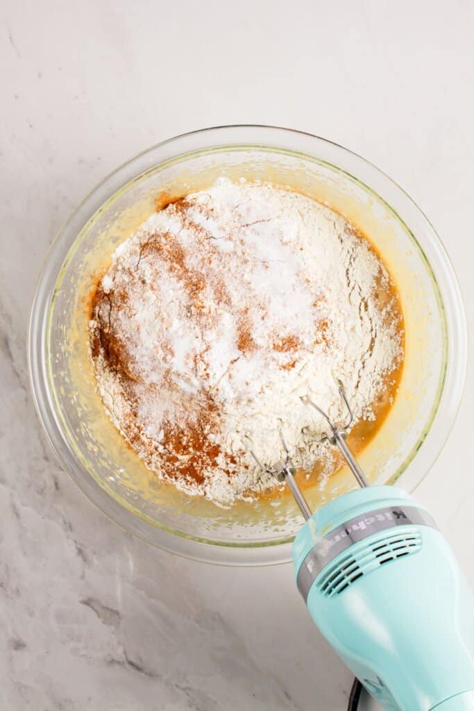 Dry ingredients being mixed into dough in a mixing bowl.