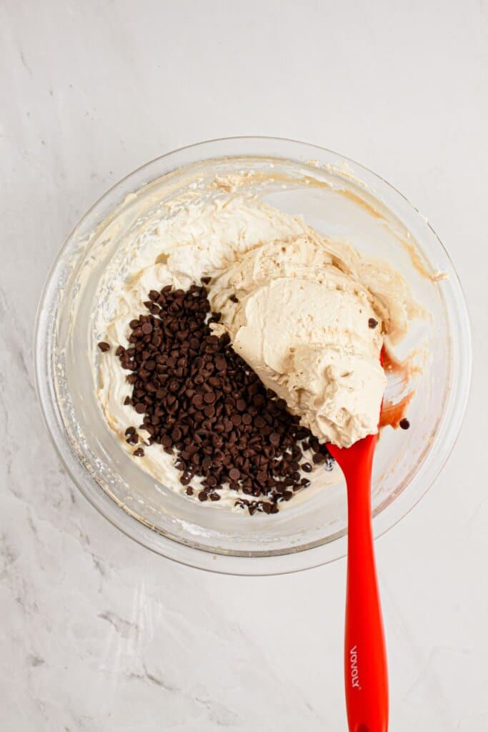 Whipped cream being mixed into batter.