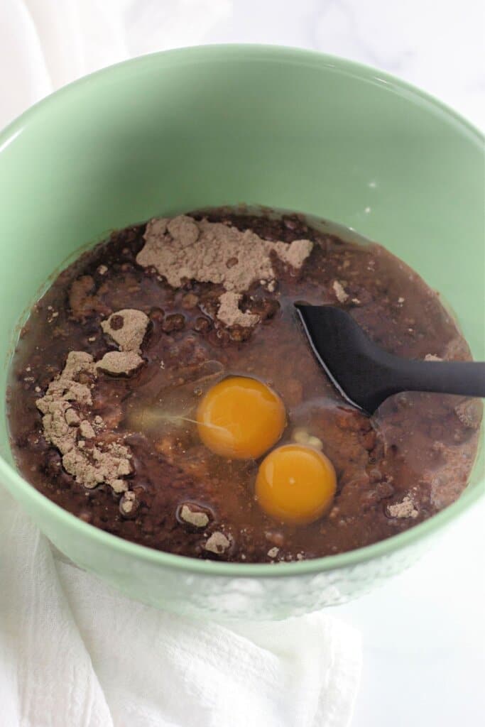 Eggs being added to batter in a mixing bowl.