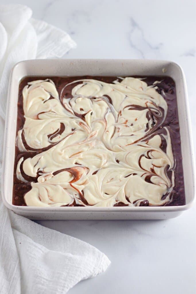 Cream cheese layered being swirled into batter.