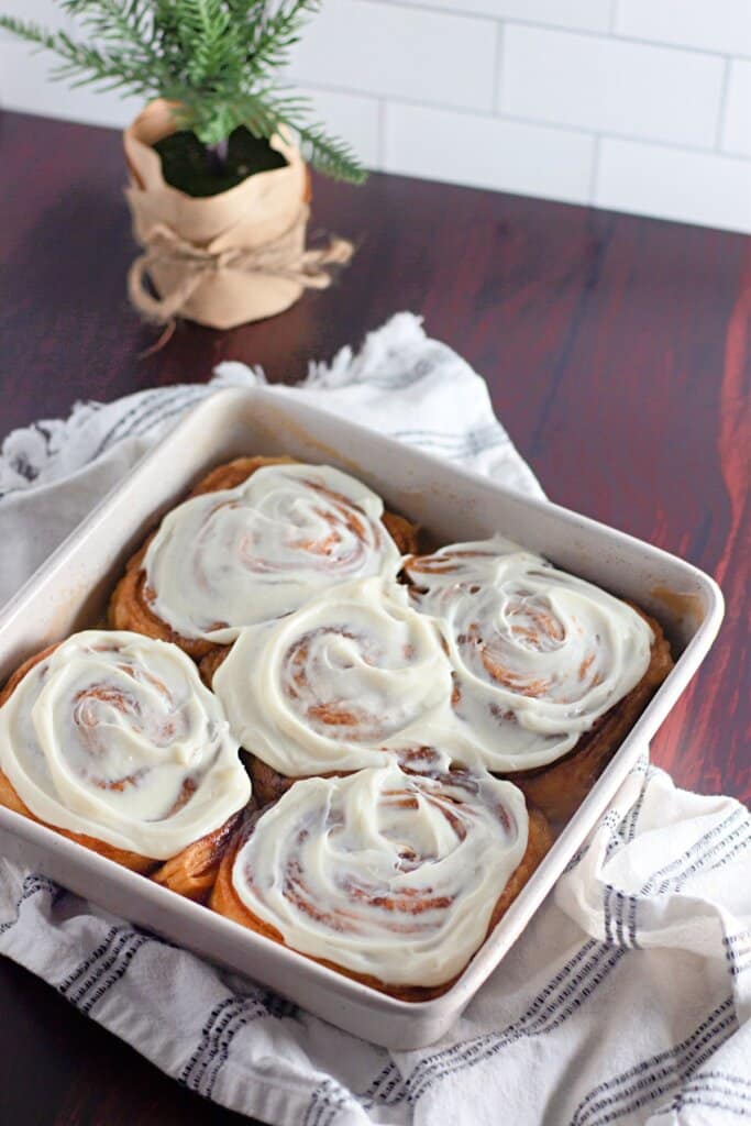 Frosted cinnamon rolls in a baking dish.