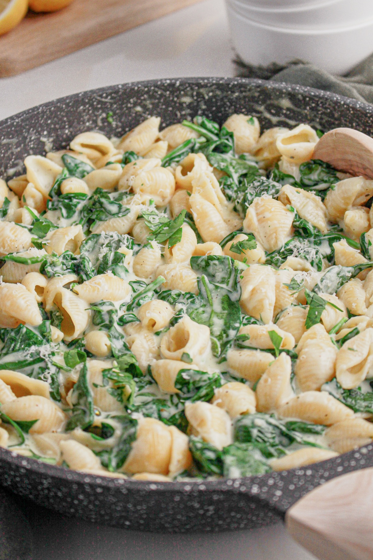 Large skillet full of creamy spinach pasta.