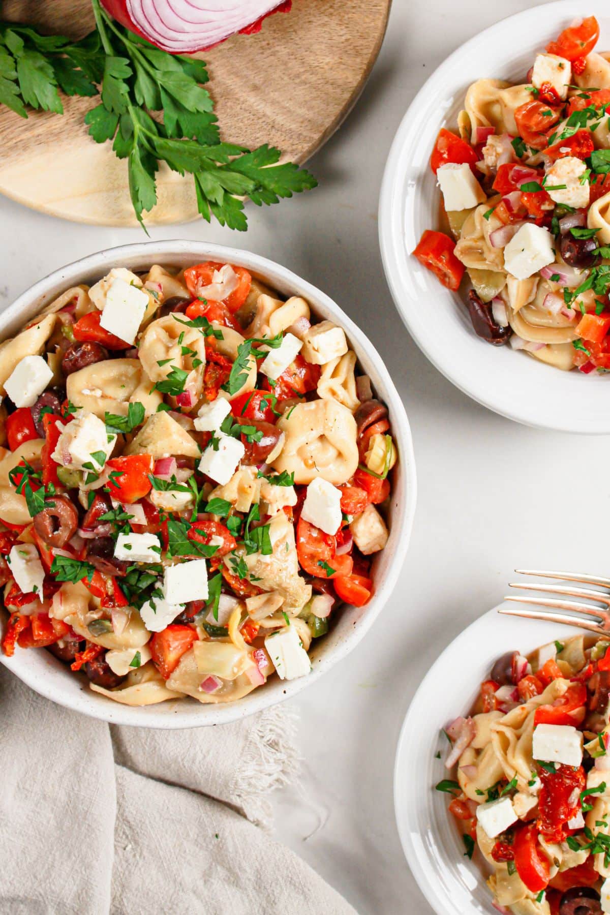 Bowls full of tortellini salad on a table.