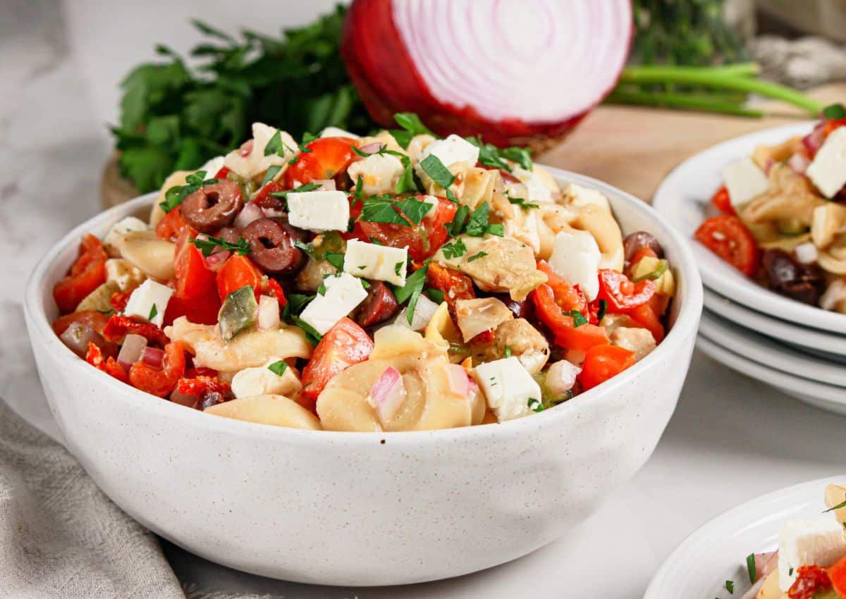 White bowl full of tortellini pasta salad.