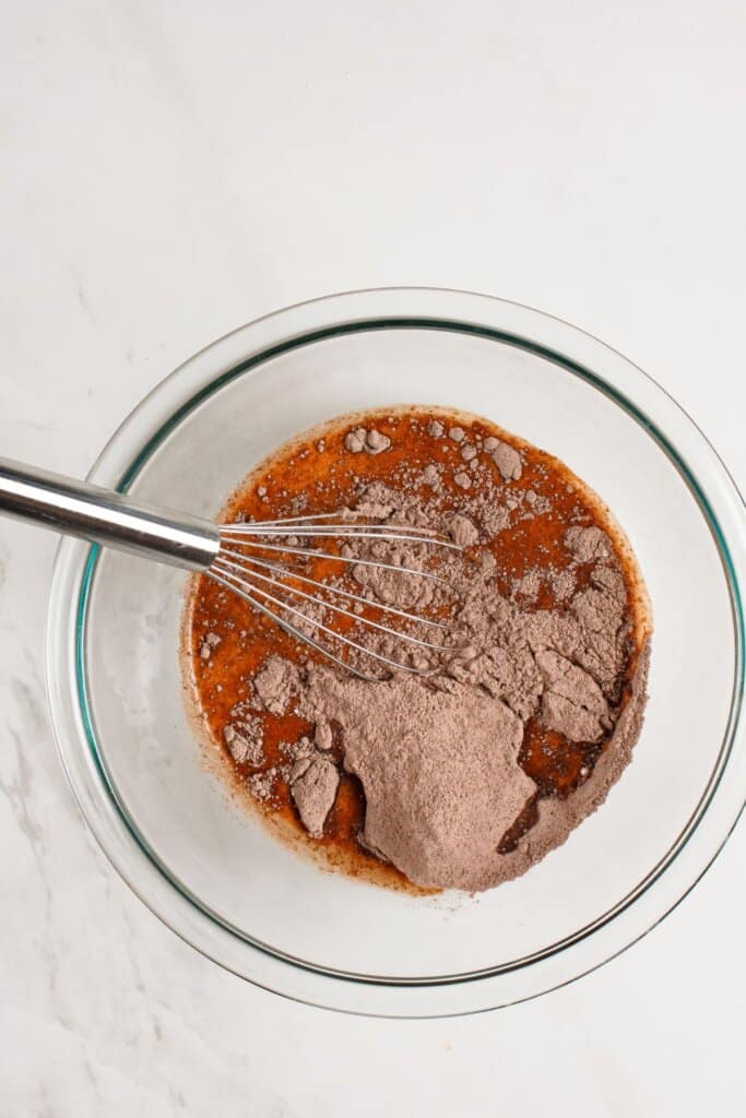 Cake mix being mixed in a glass bowl.