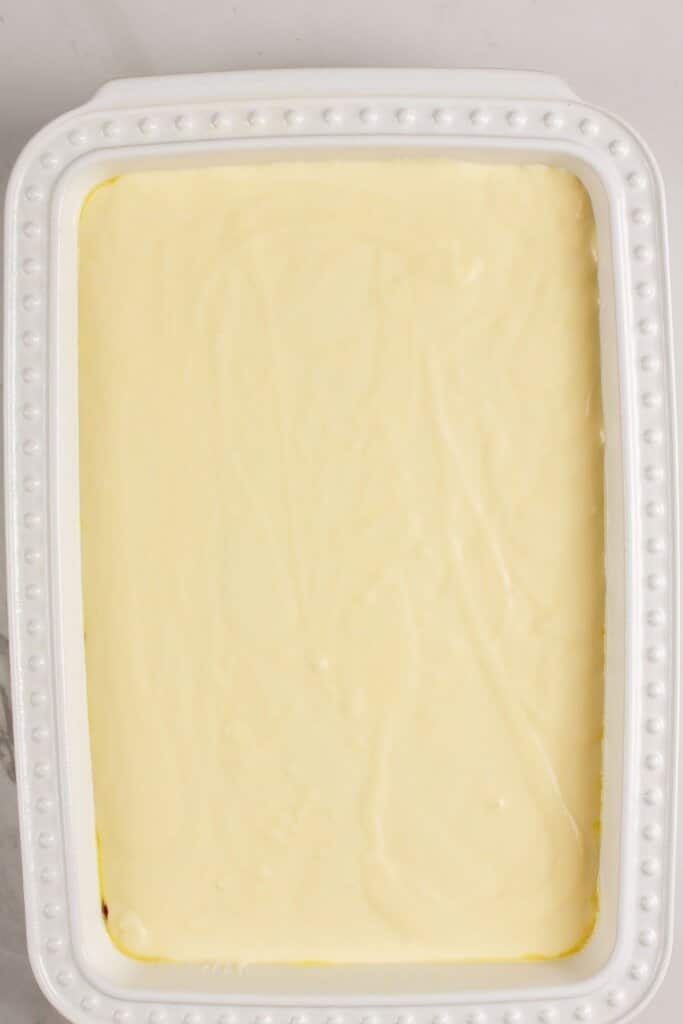 Cheese being spread on top of dessert.