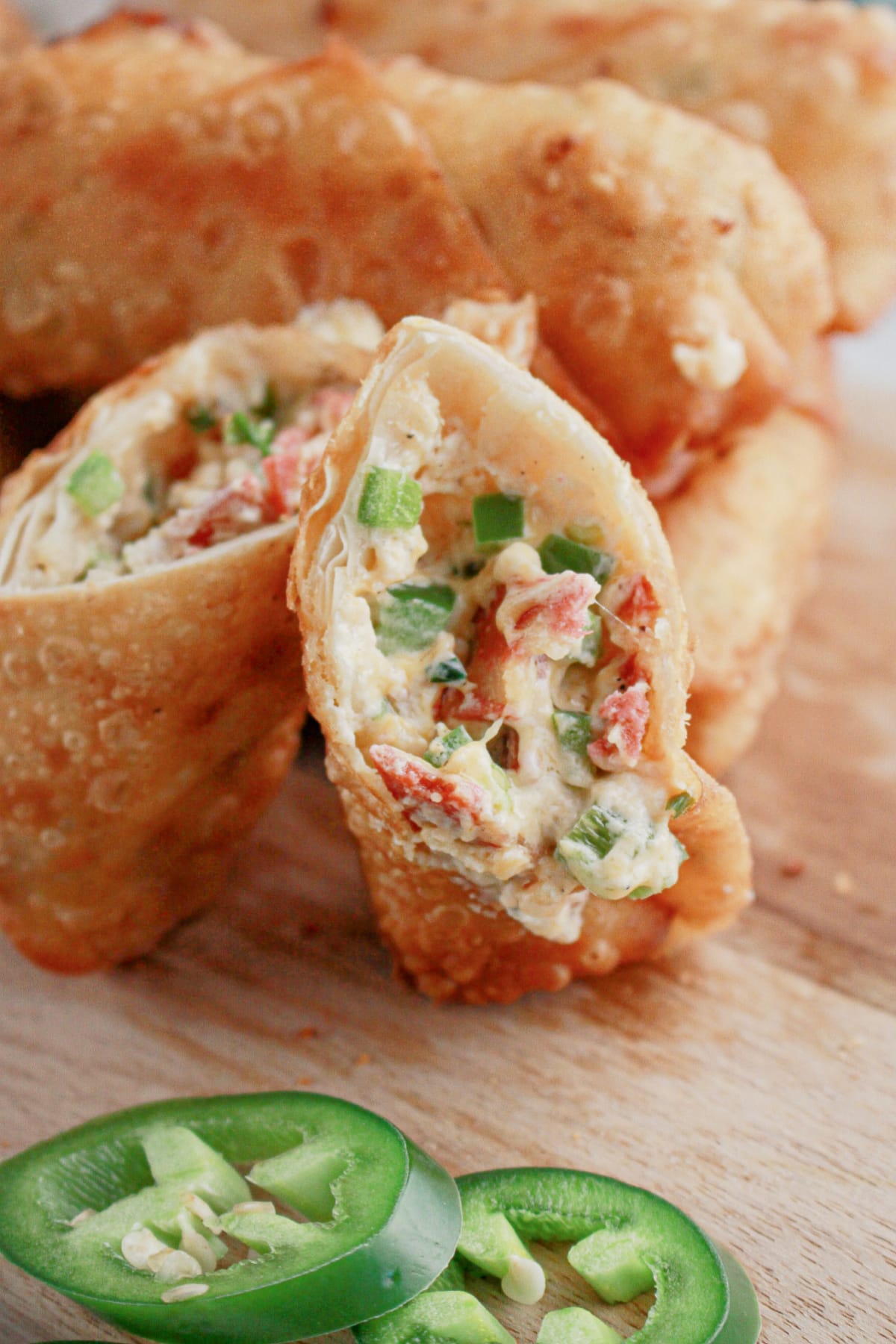 Jalapeno popper egg roll opened on a cutting board.