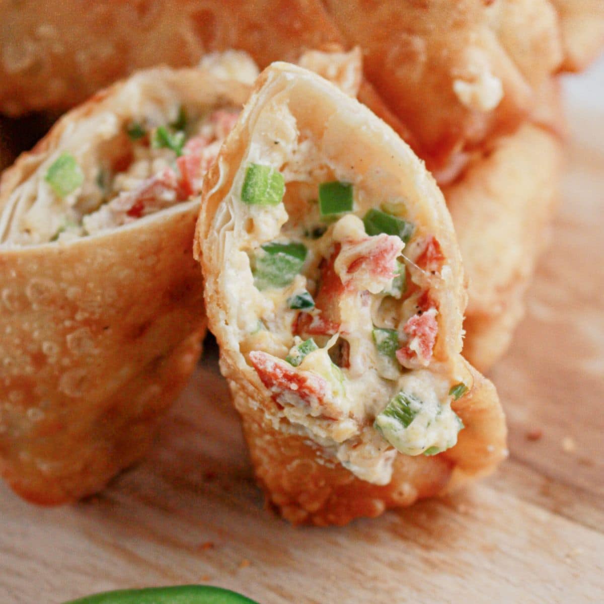 Jalapeno popper egg roll opened on a cutting board.