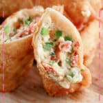 Jalapeno popper egg roll opened on a cutting board.