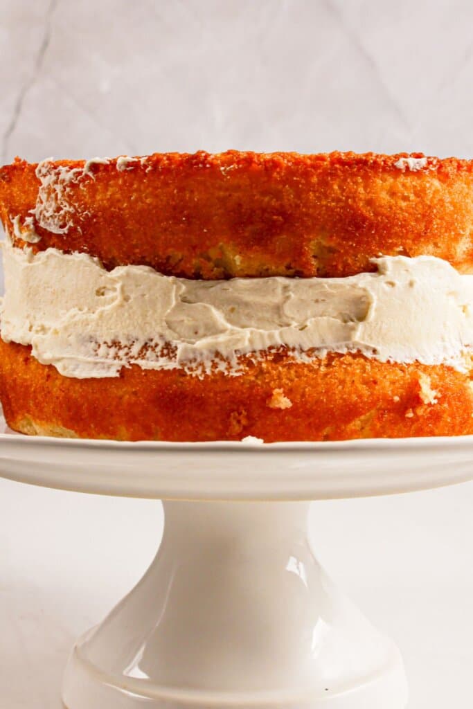 Cake being layered on a cake stand.