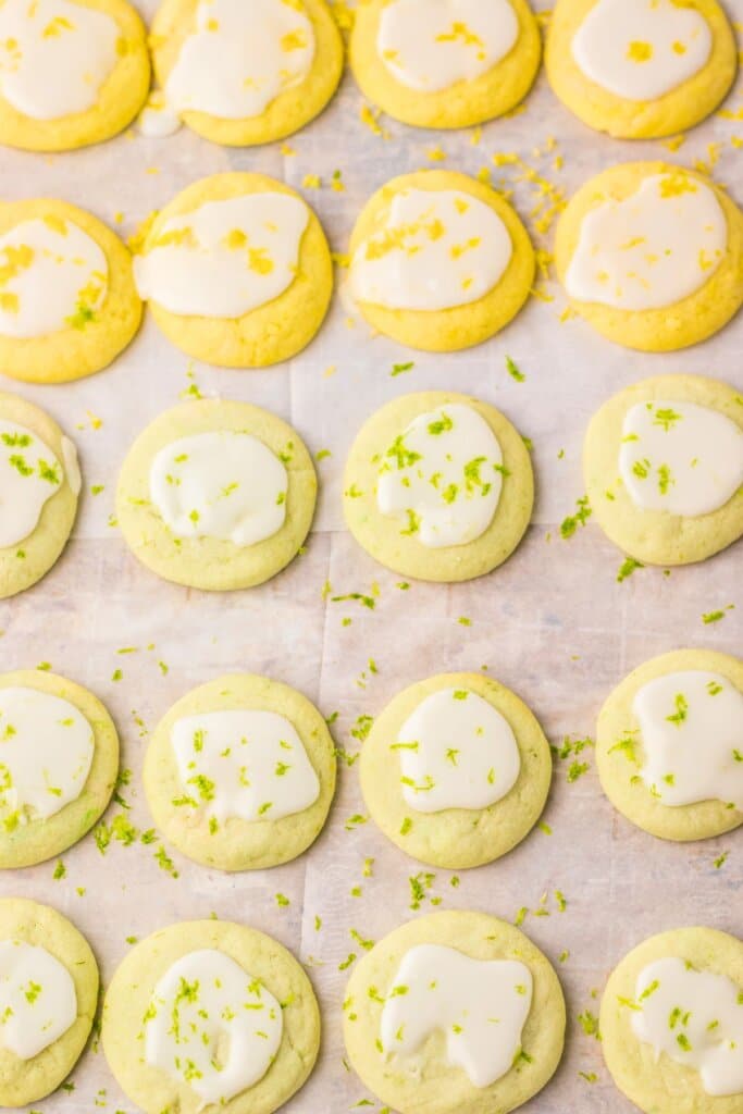 Icing and zest being added to the top of cookies.